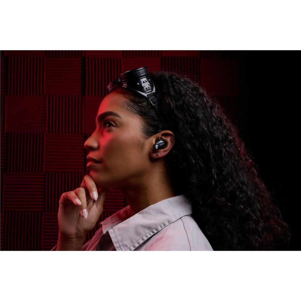 Wireless earbuds worn in-ear on a woman in a studio