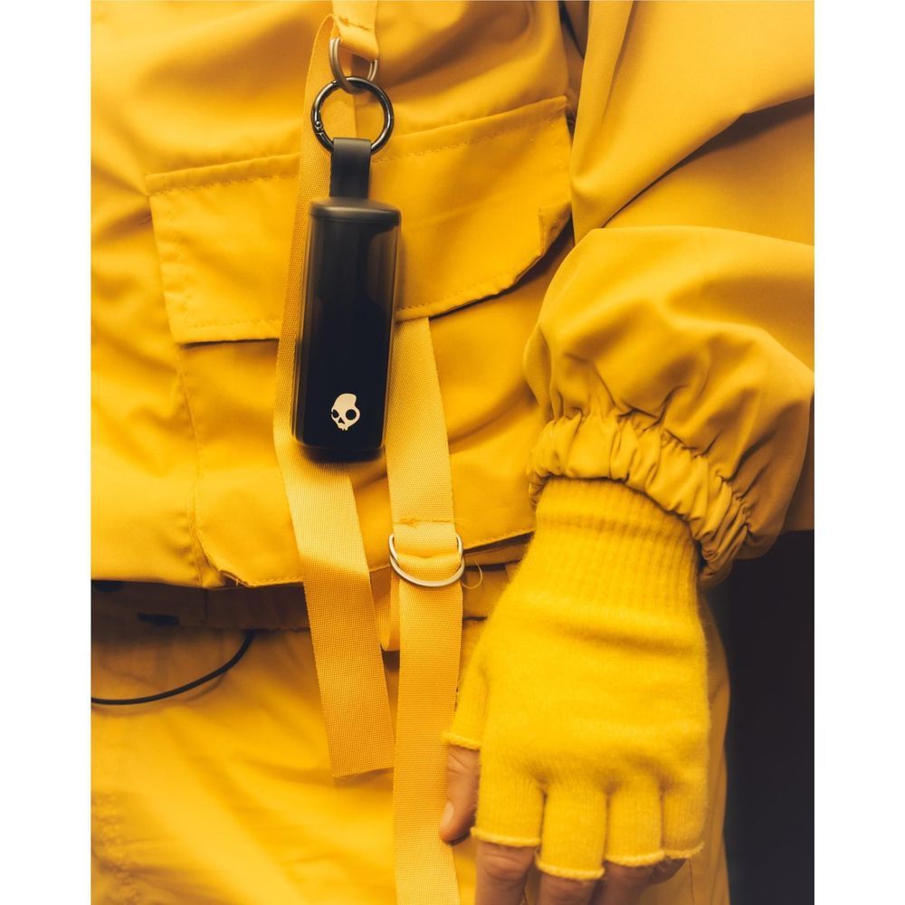 Black charging case keychain attached to a yellow jacket