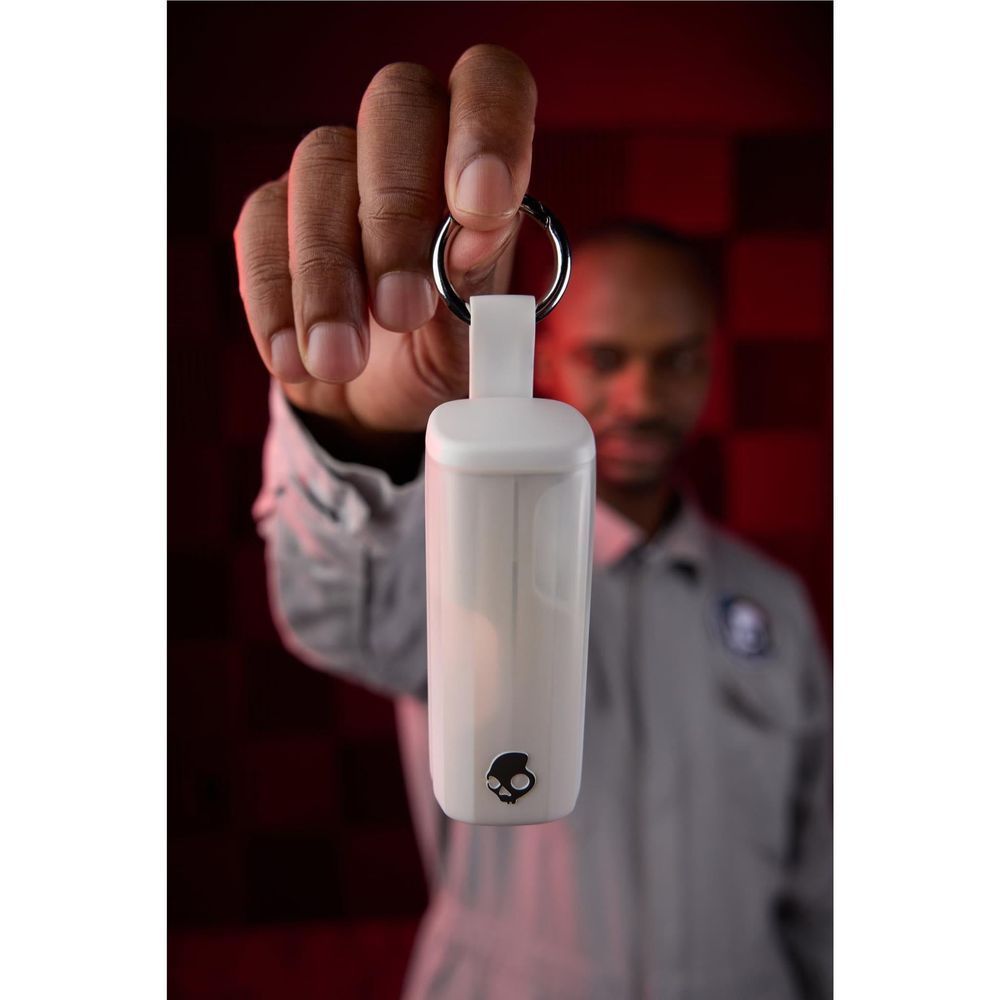 White wireless earbuds charging case on a keychain, held in hand