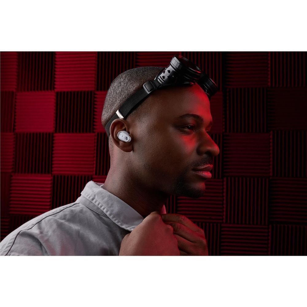 White wireless earbuds in ear with black headband detail