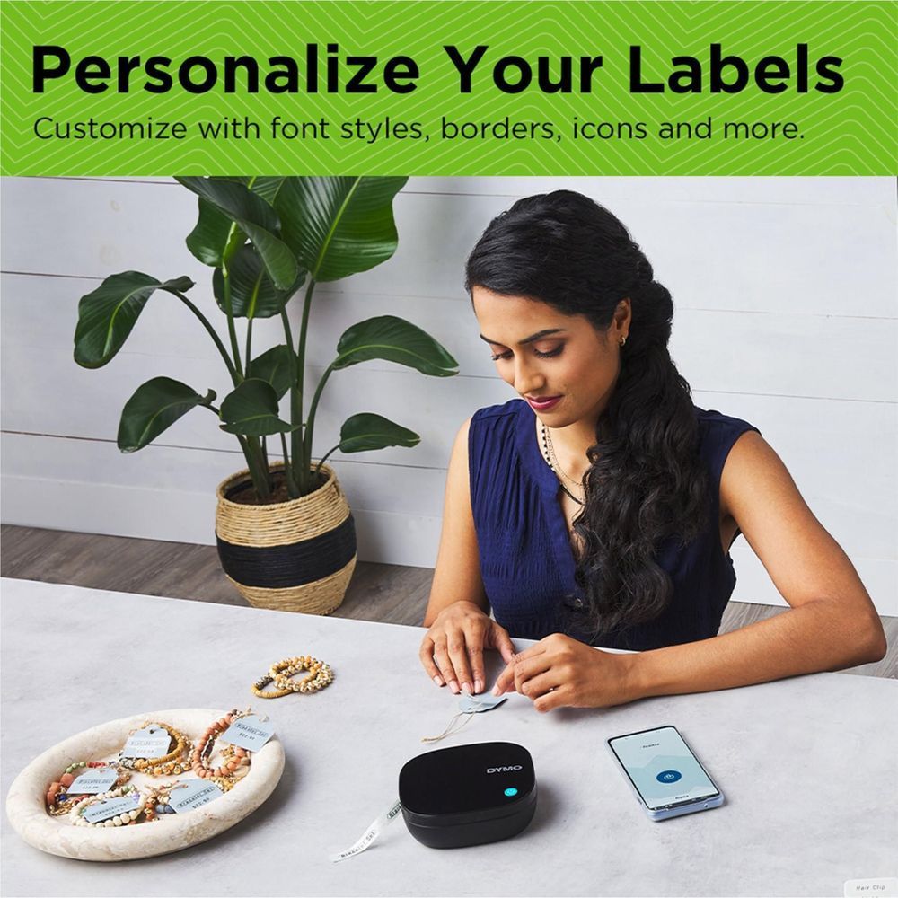 DYMO LetraTag label maker on a table with smartphone and label materials nearby