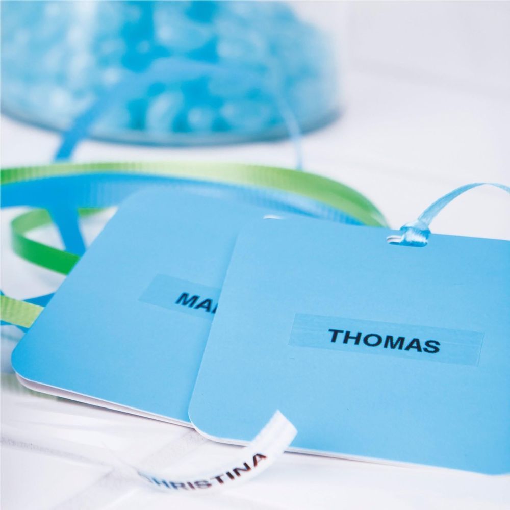 Clear plastic labels with printed text being placed onto a card