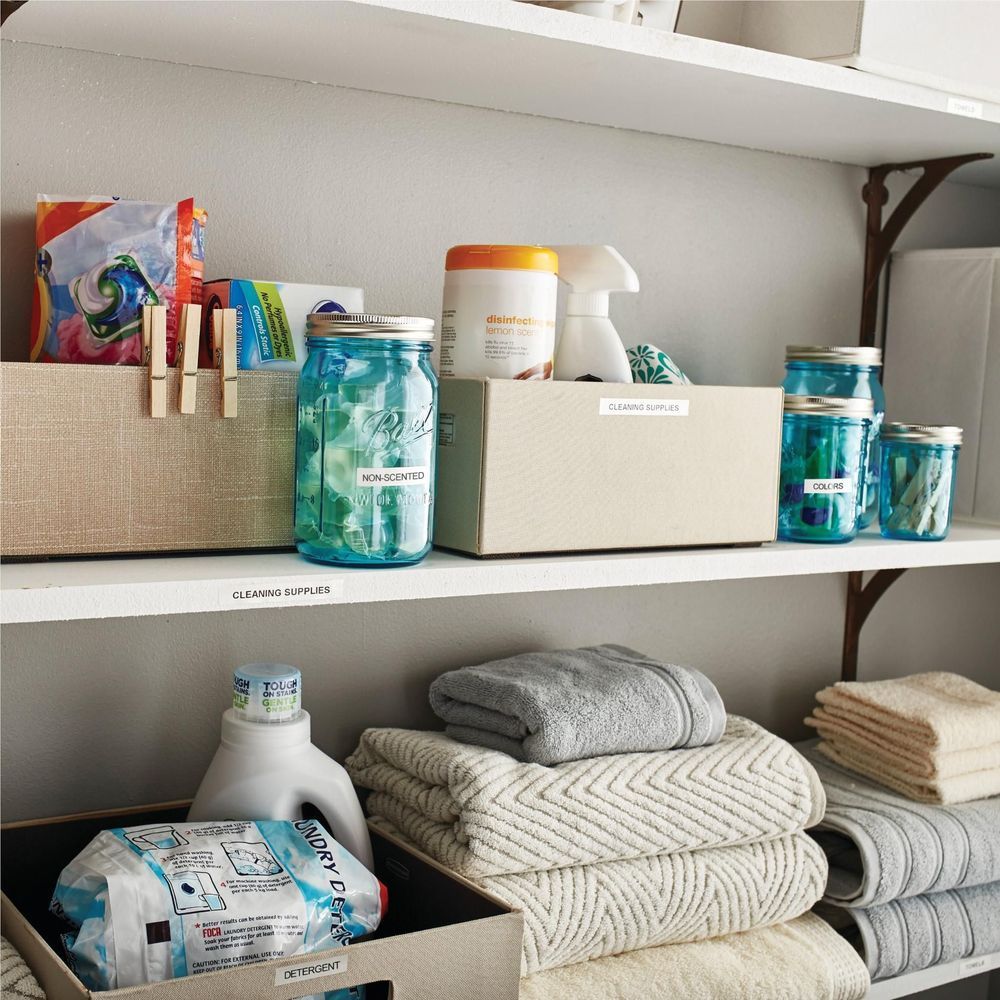 Labeled storage jars and boxes on a shelf with clear label tags