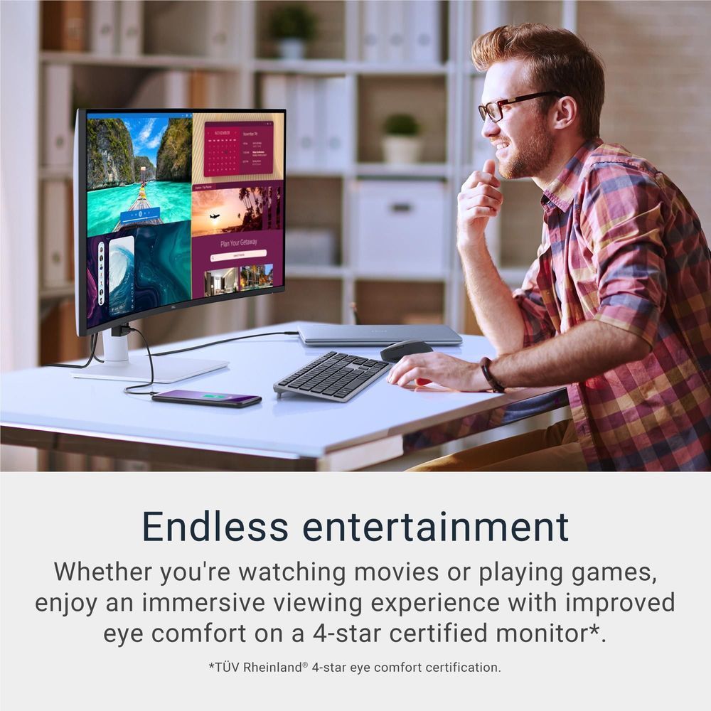 Desktop monitor displaying colorful apps while a person works at a home office desk