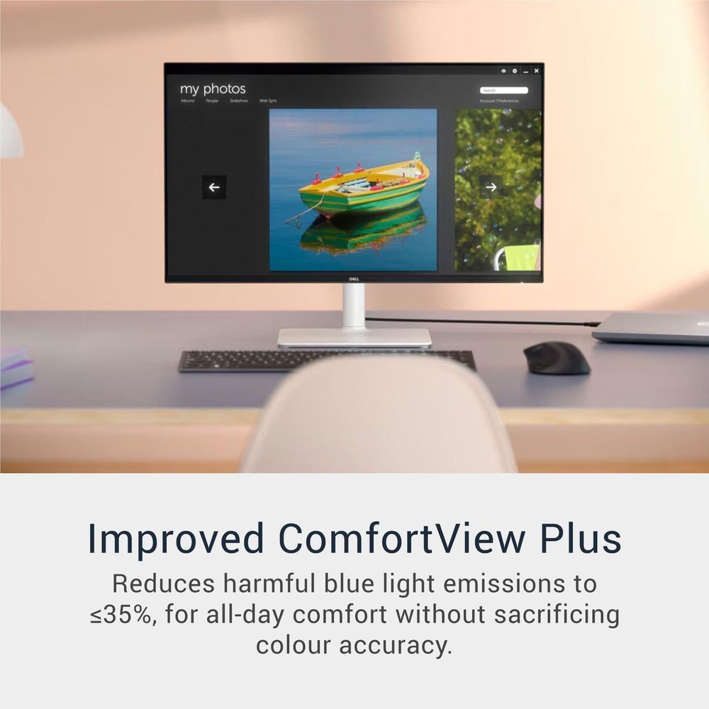 Office monitor displaying a photo gallery interface with keyboard and mouse nearby