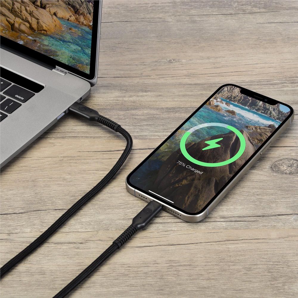 USB-C cable connected to laptop and smartphone on a wooden desk