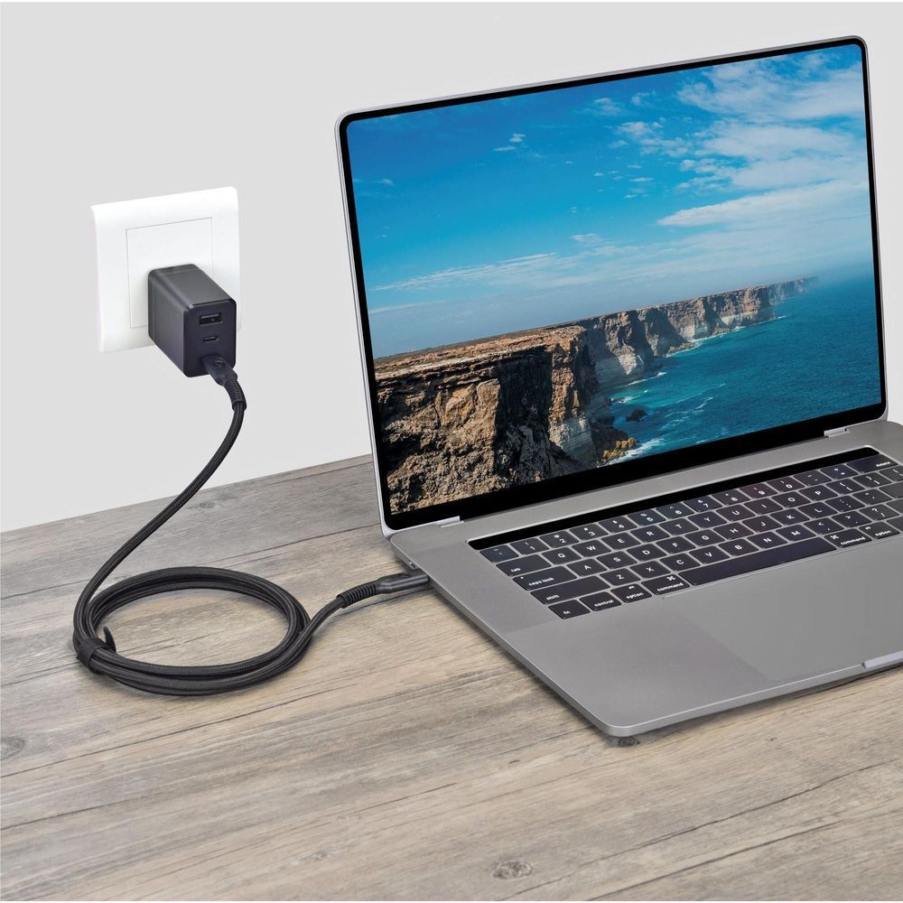 Black USB-C to USB-C cable connected between a laptop and wall power outlet