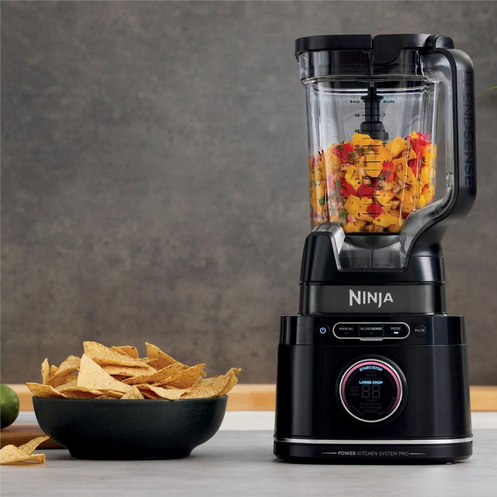 Ninja blender with clear pitcher filled with chopped ingredients; black base