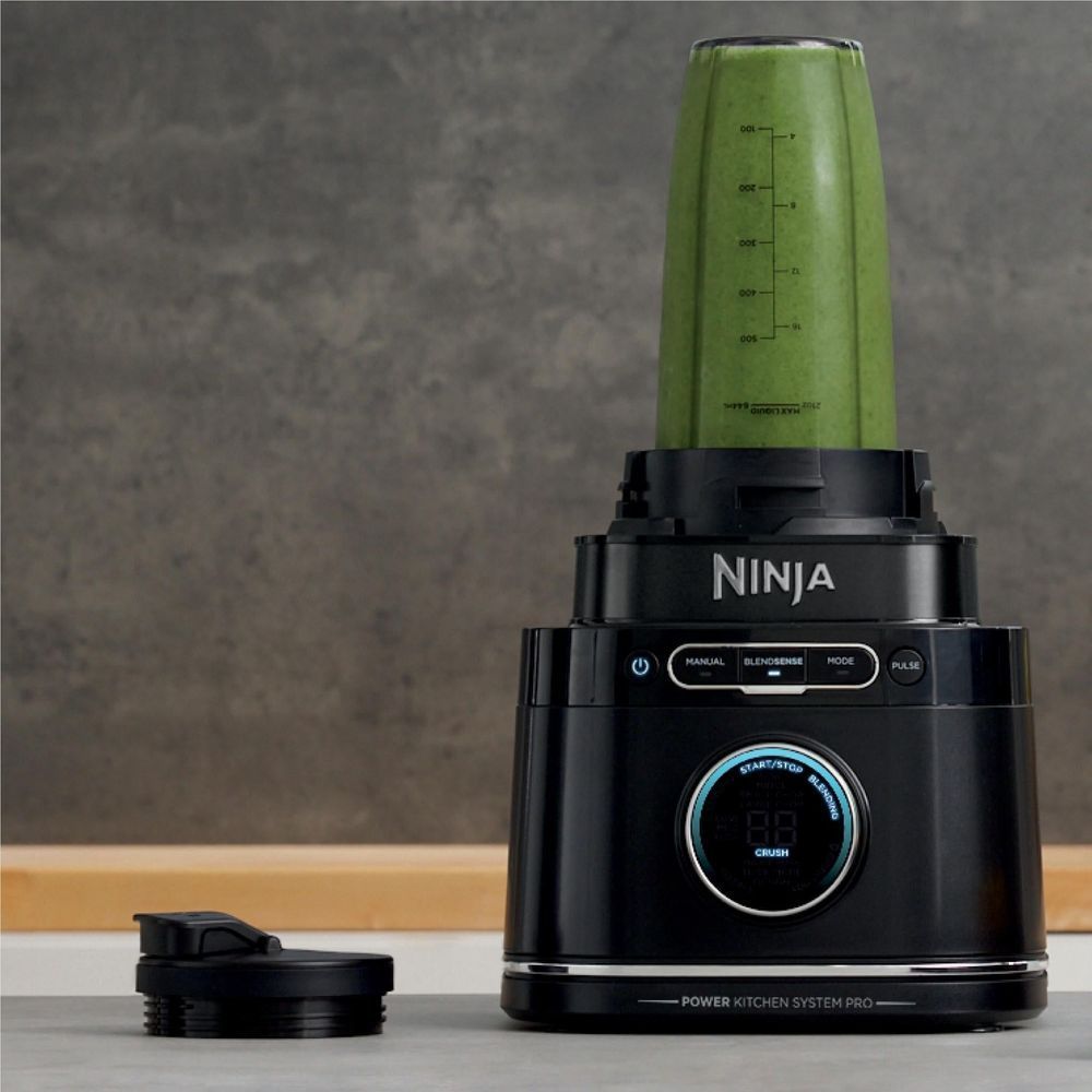 Ninja blender pitcher filled with green puree; black control base