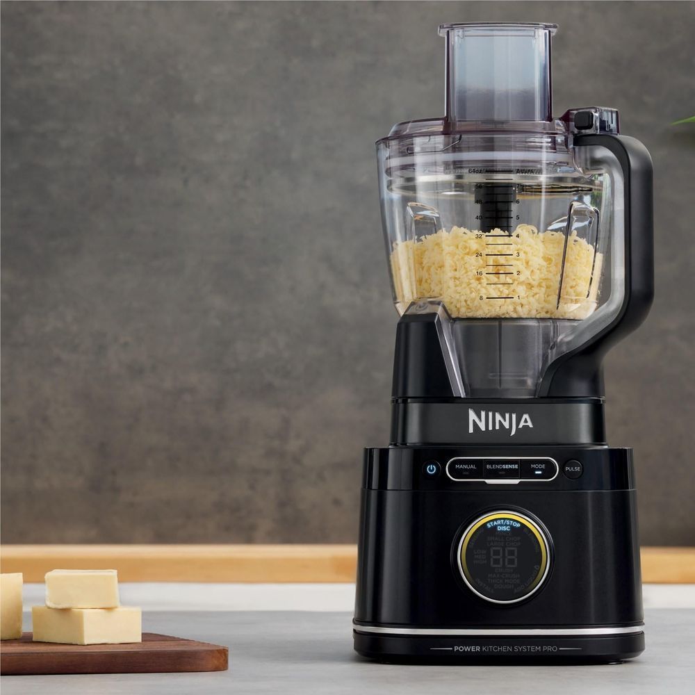 Ninja blender with clear pitcher filled with grated cheese