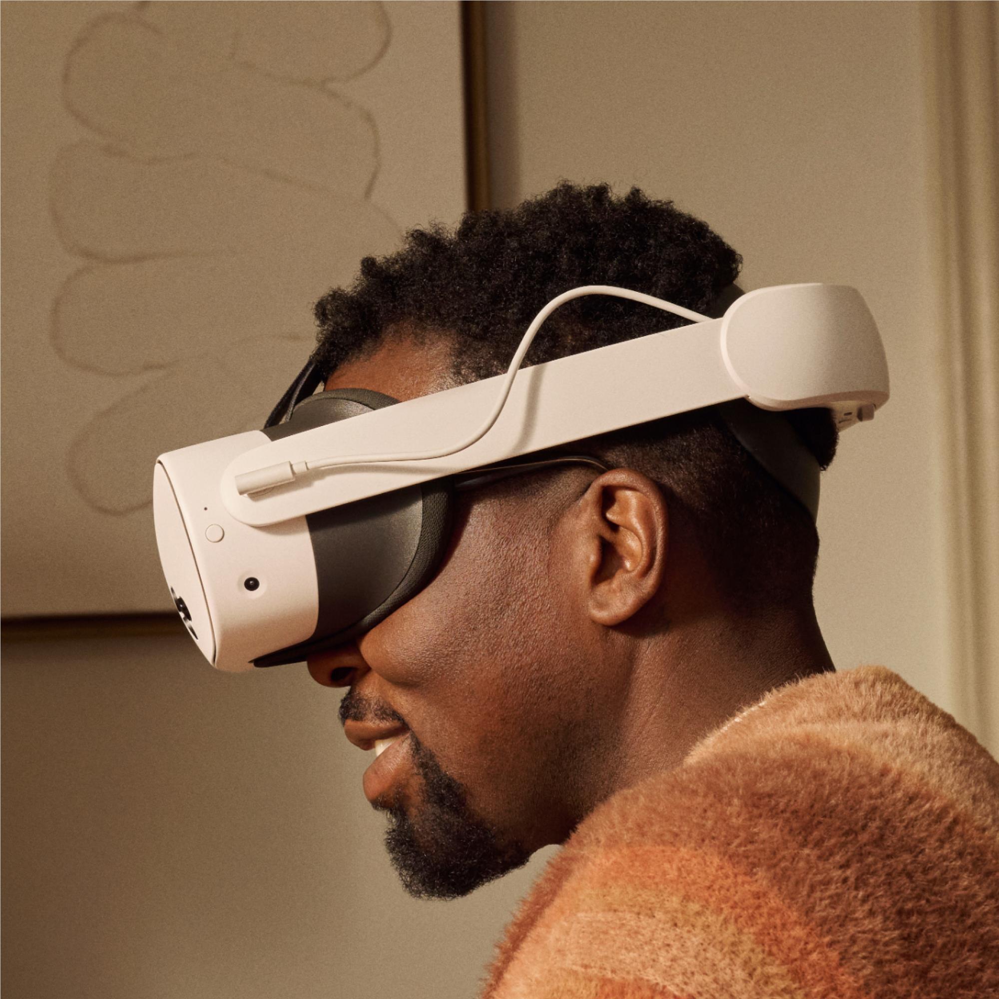 White VR headset on person’s head with black battery strap
