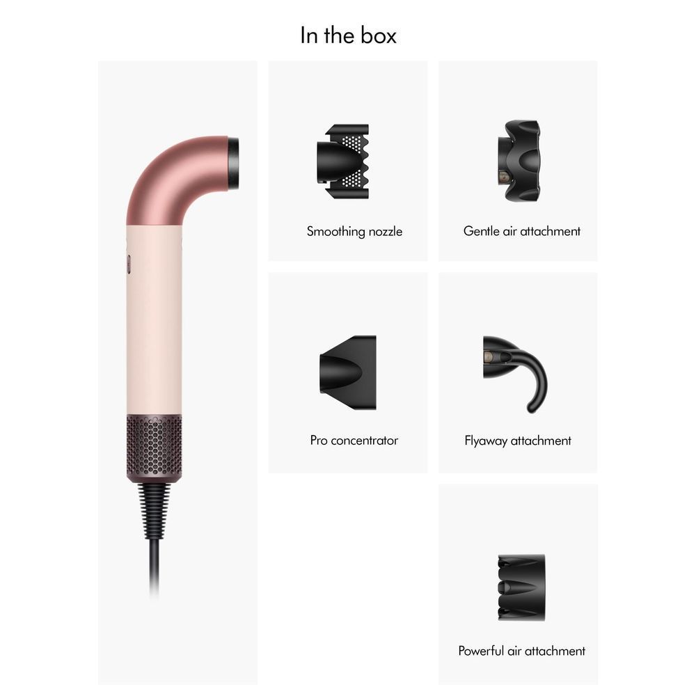 Hair dryer in the box with ceramic pink body, rose-gold finish, and black attachments