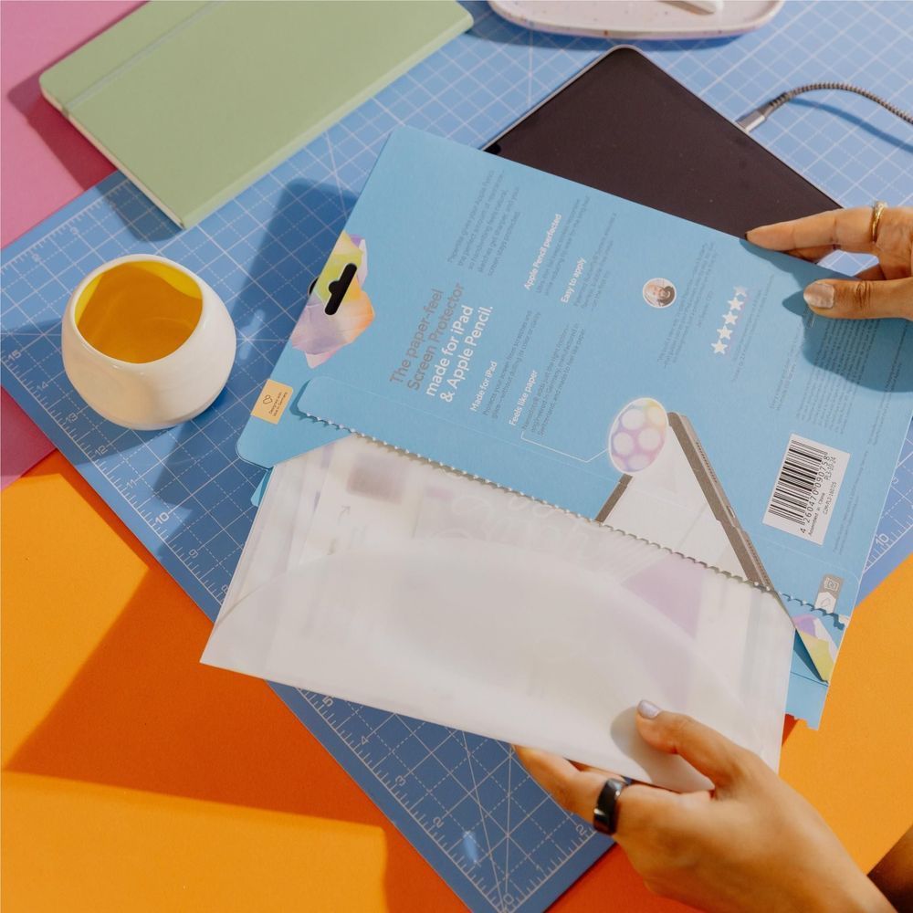 Screen protector sheet on cutting mat; protective film pieces and backing