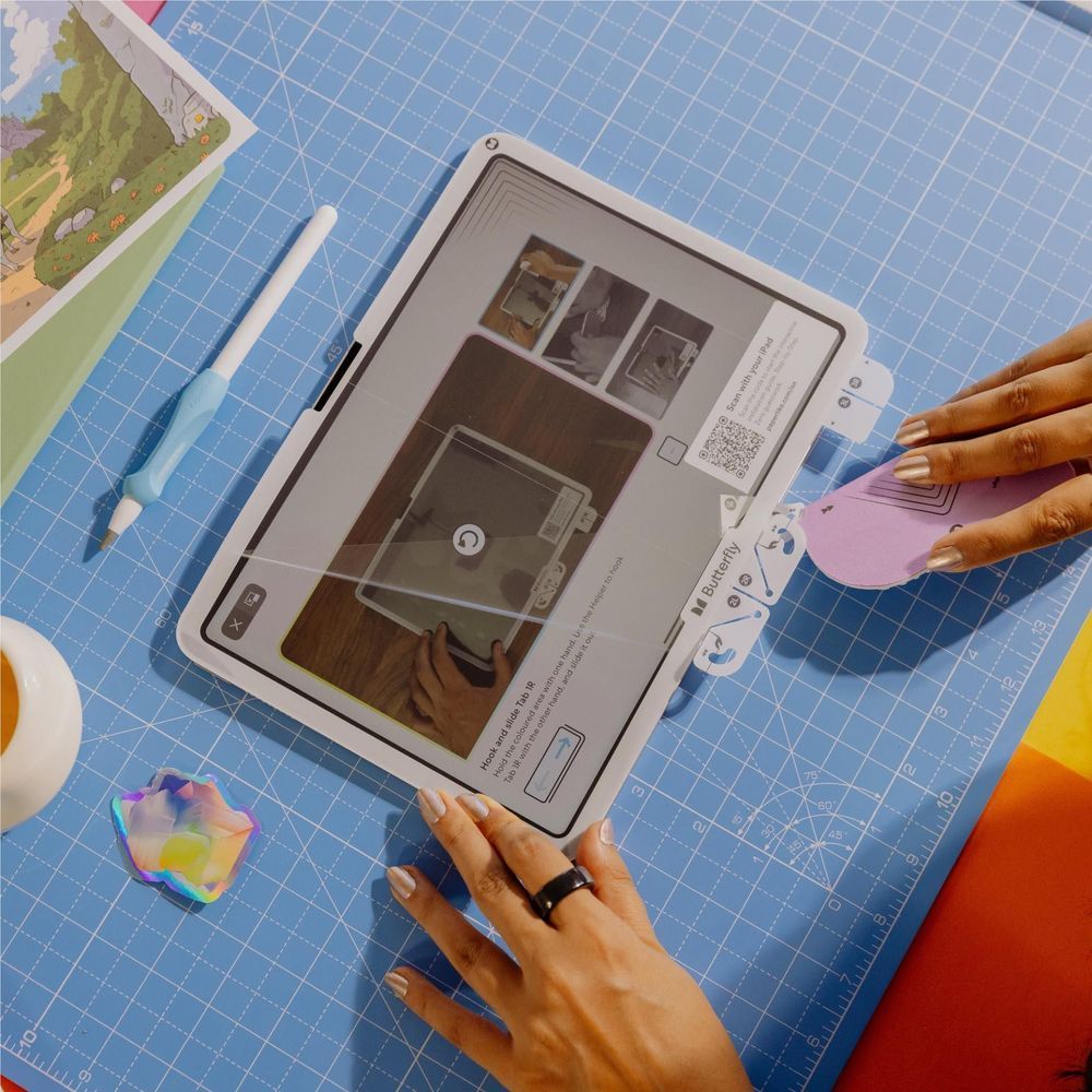 iPad with screen protector being smoothed by hands over a cutting mat
