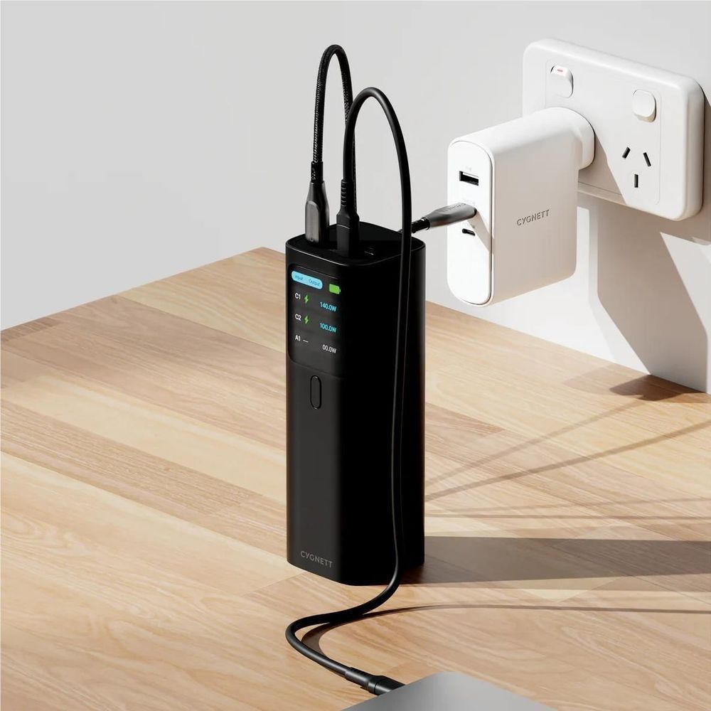Black power bank with cables plugged in near wall outlet