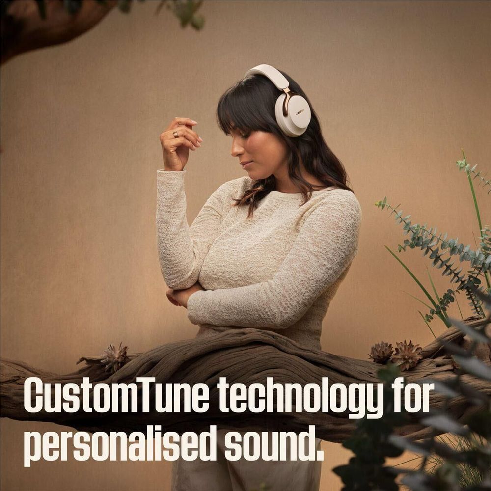 Bose QuietComfort Ultra headphones worn over ears in Driftwood Sand