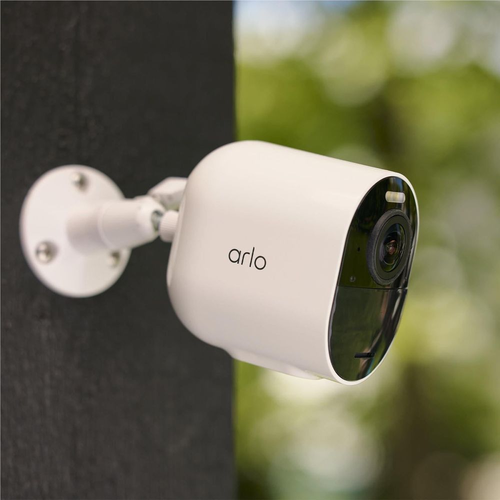 White arlo outdoor security camera add-on attached to an exterior wall
