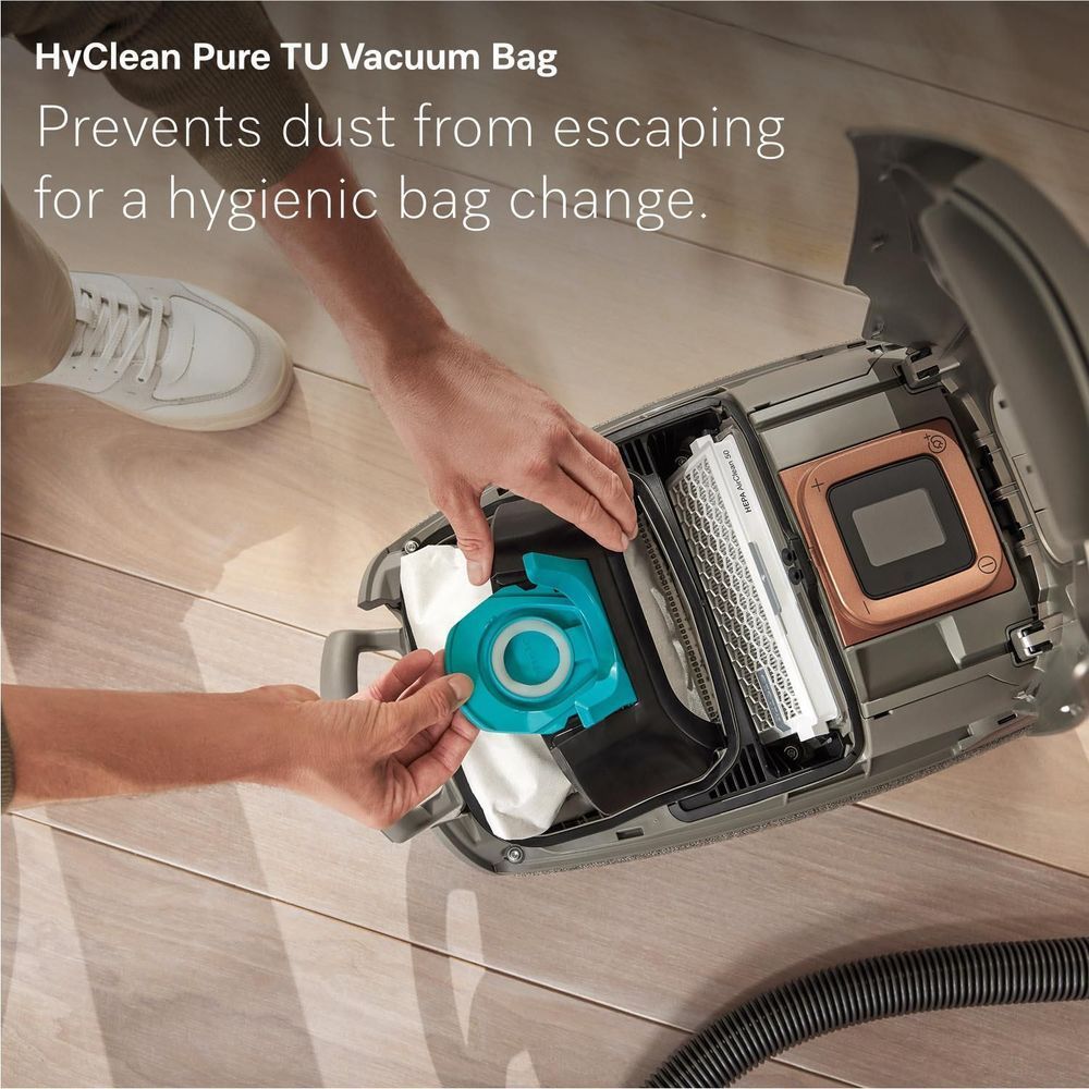 Miele vacuum bag compartment showing HEPA filter and teal vacuum cleaner bag