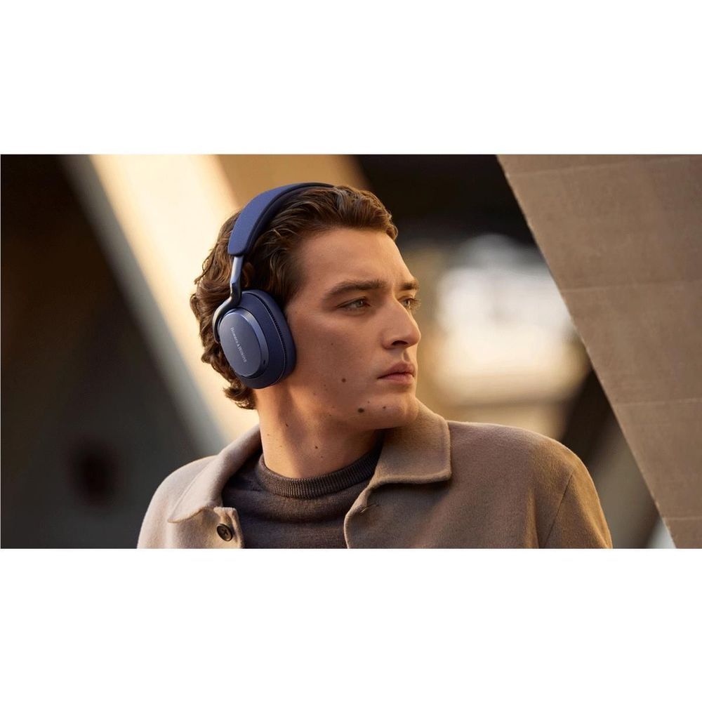 Indigo blue over-ear headphones worn by person in casual jacket