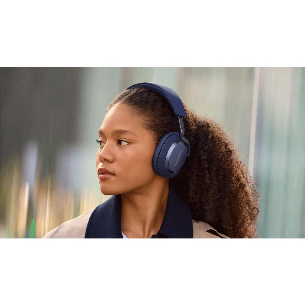 Indigo blue over-ear headphones worn by person with curly hair