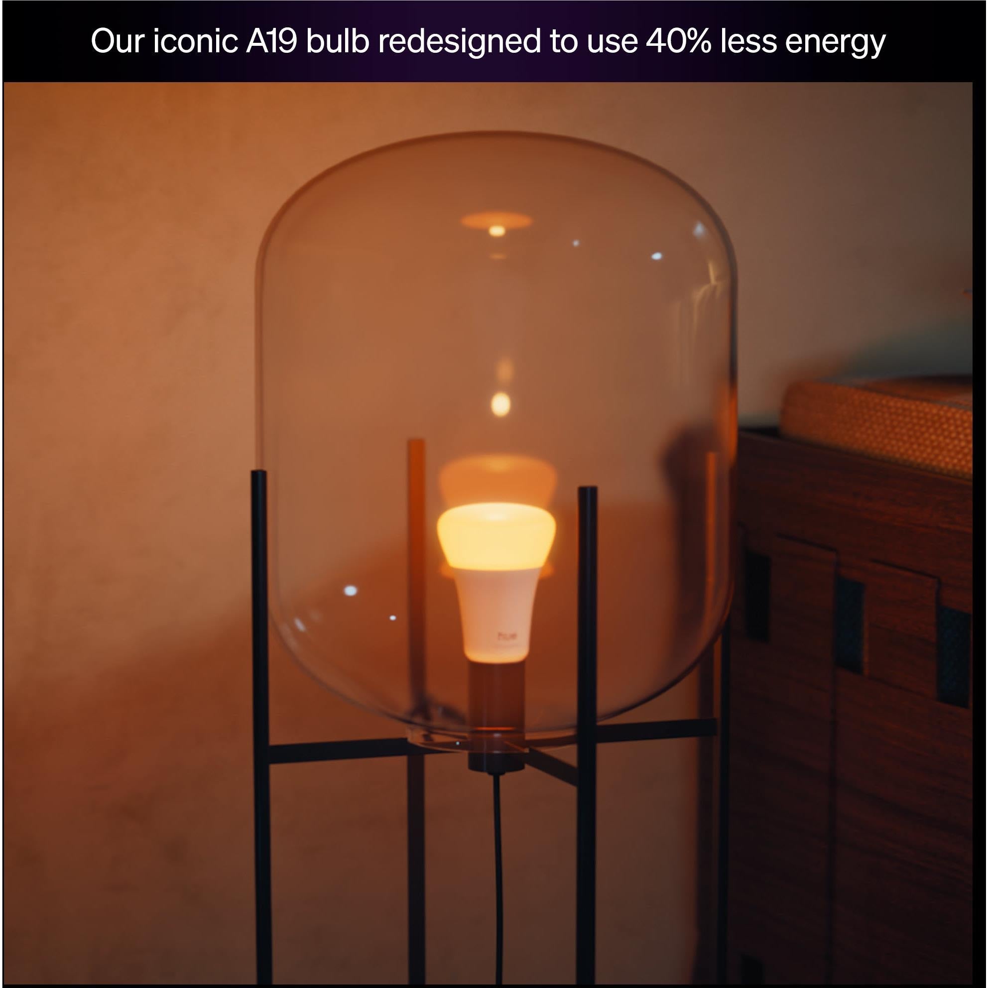 Smart LED bulb emitting warm yellow light behind clear protective cover