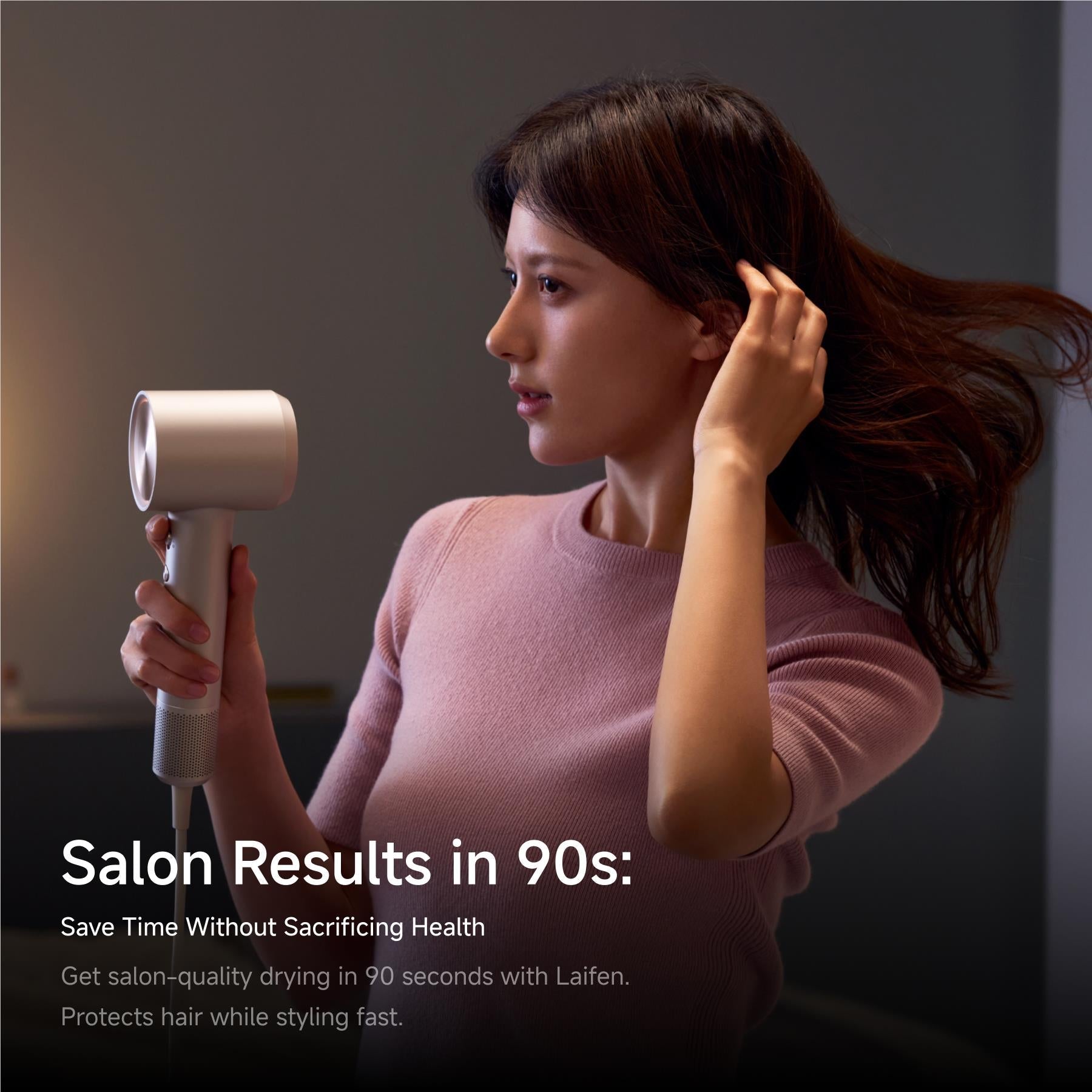Platinum hair dryer with concentrator nozzle, held in hand for styling