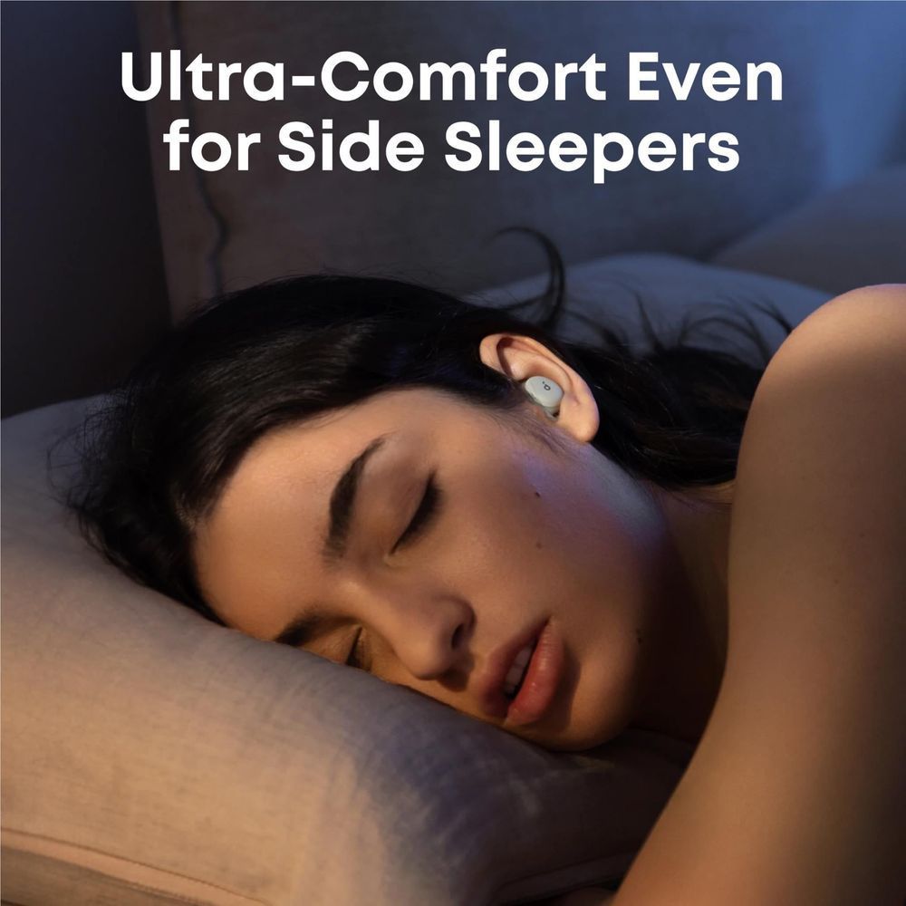 Wireless sleep earbuds in a side sleeper's ear on a pillow