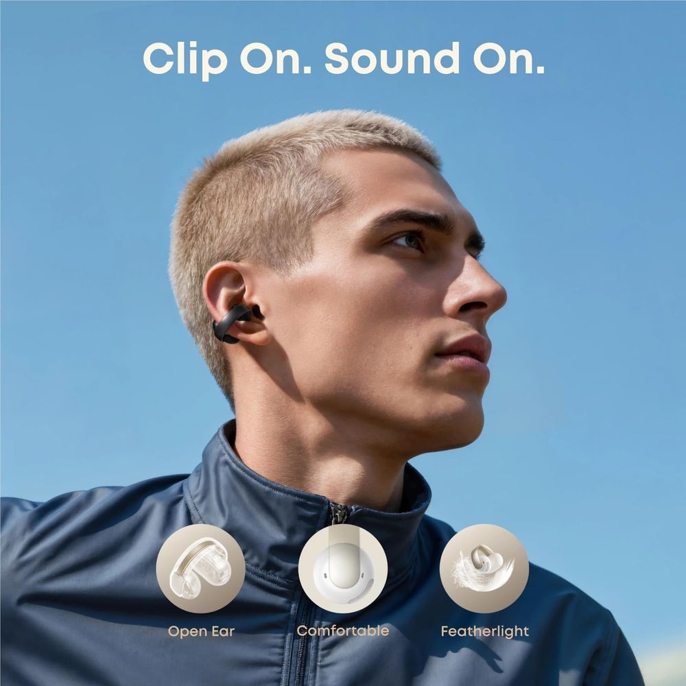 Black open-ear clip-on earbuds worn on a man’s ears, clip-on earhooks visible.