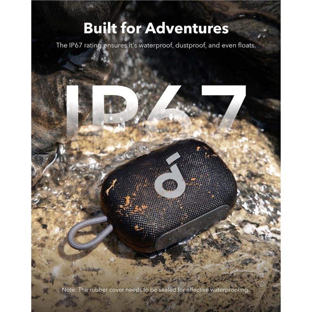 Black portable Bluetooth speaker with textured fabric, keyring strap, and splash background