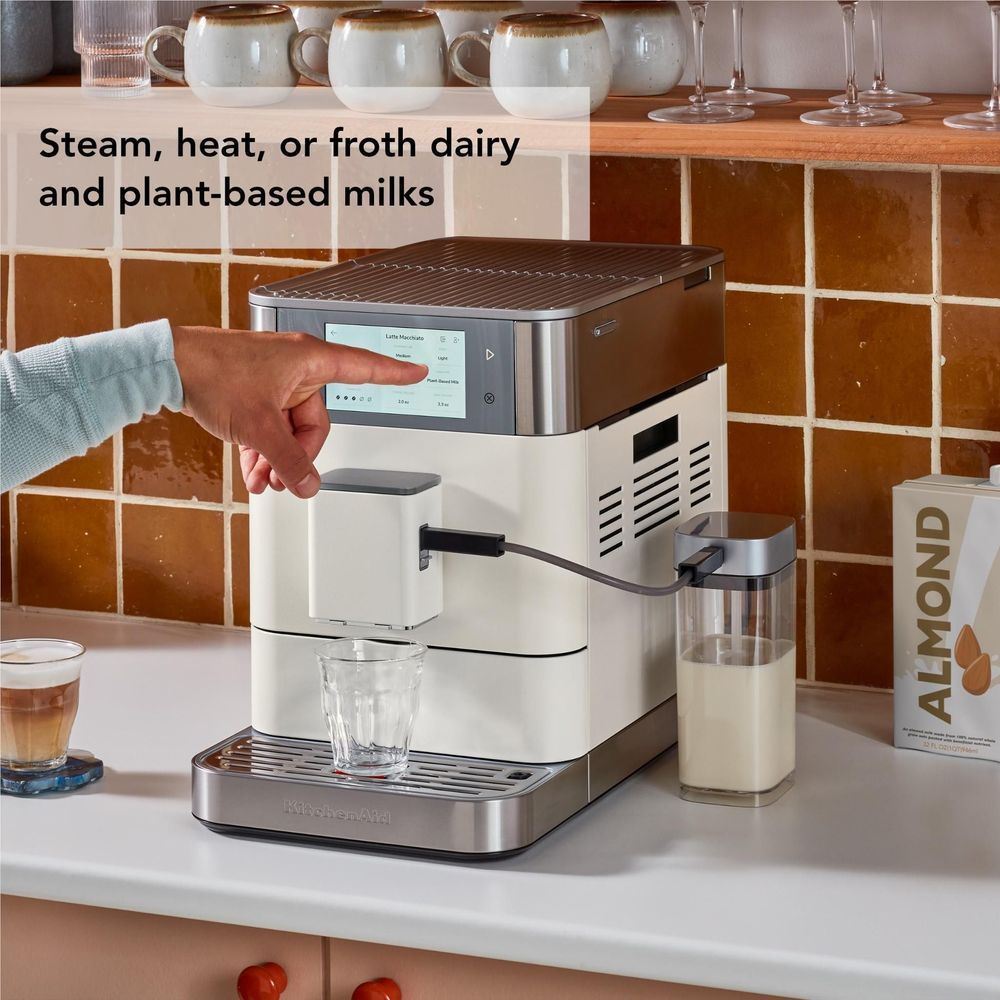 White and stainless espresso machine with steam wand and glass milk container