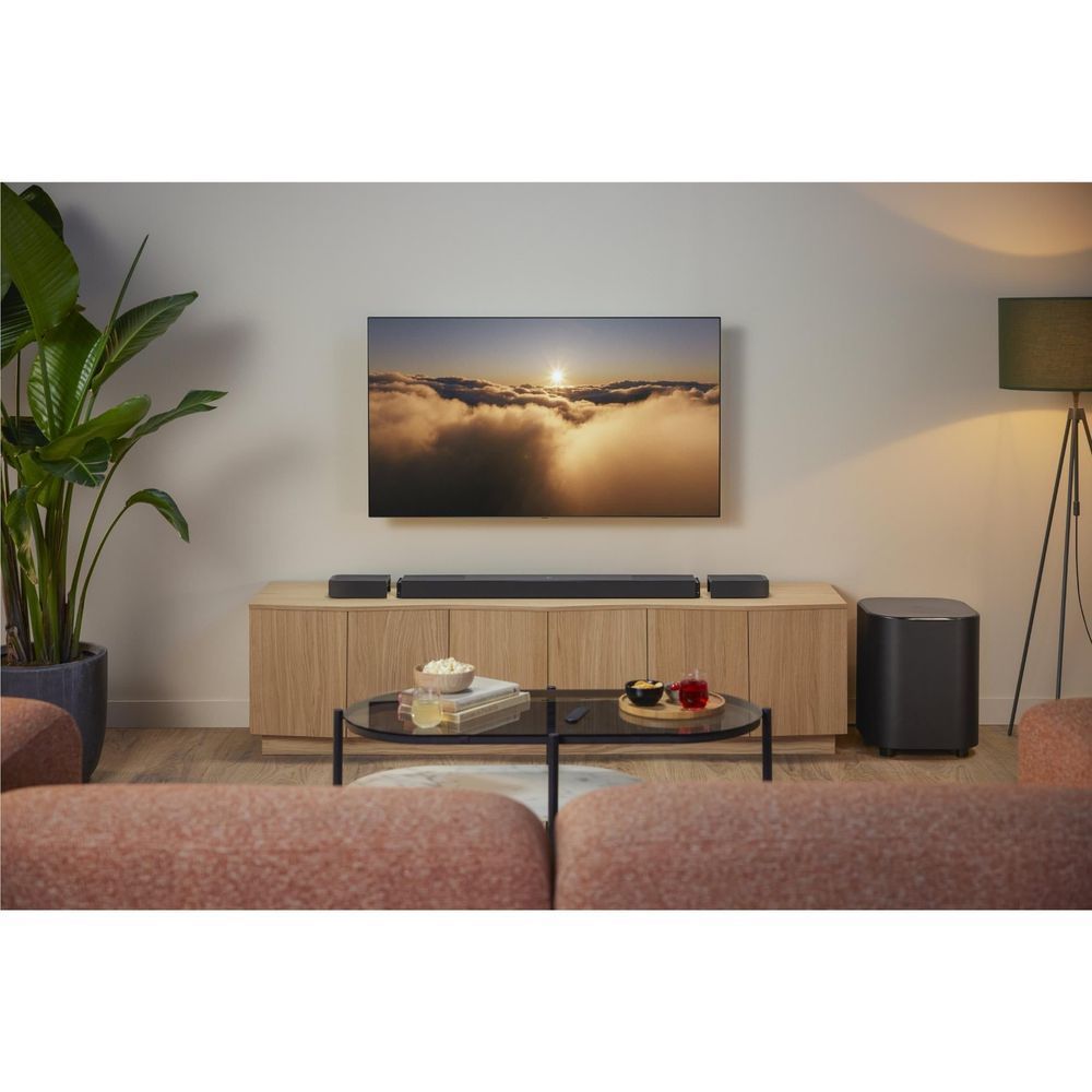 Black soundbar with subwoofer and detachable speakers in a living room setup