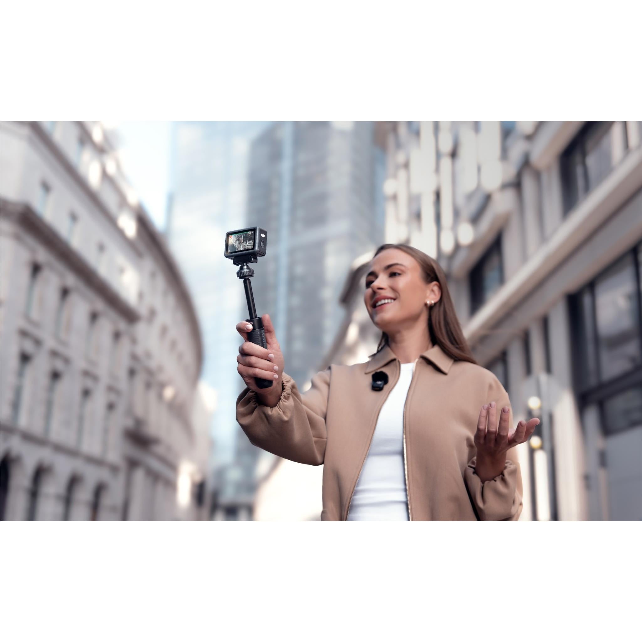 DJI action camera mounted on pole held by a person