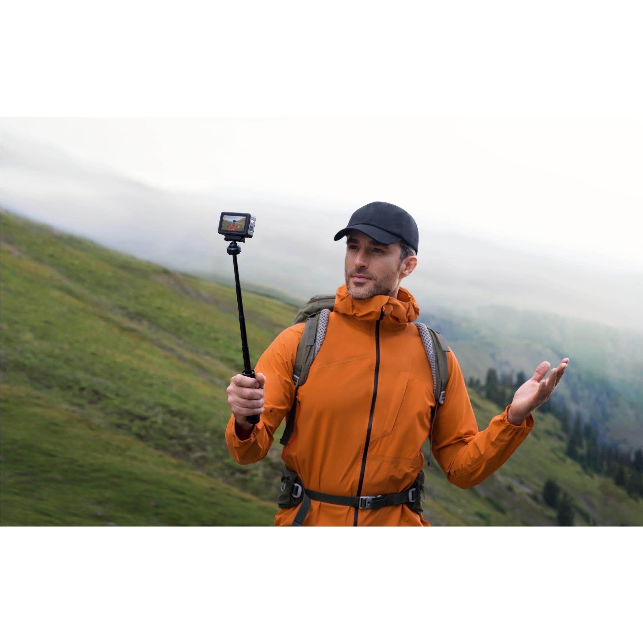 DJI action camera on pole held by an outdoor hiker