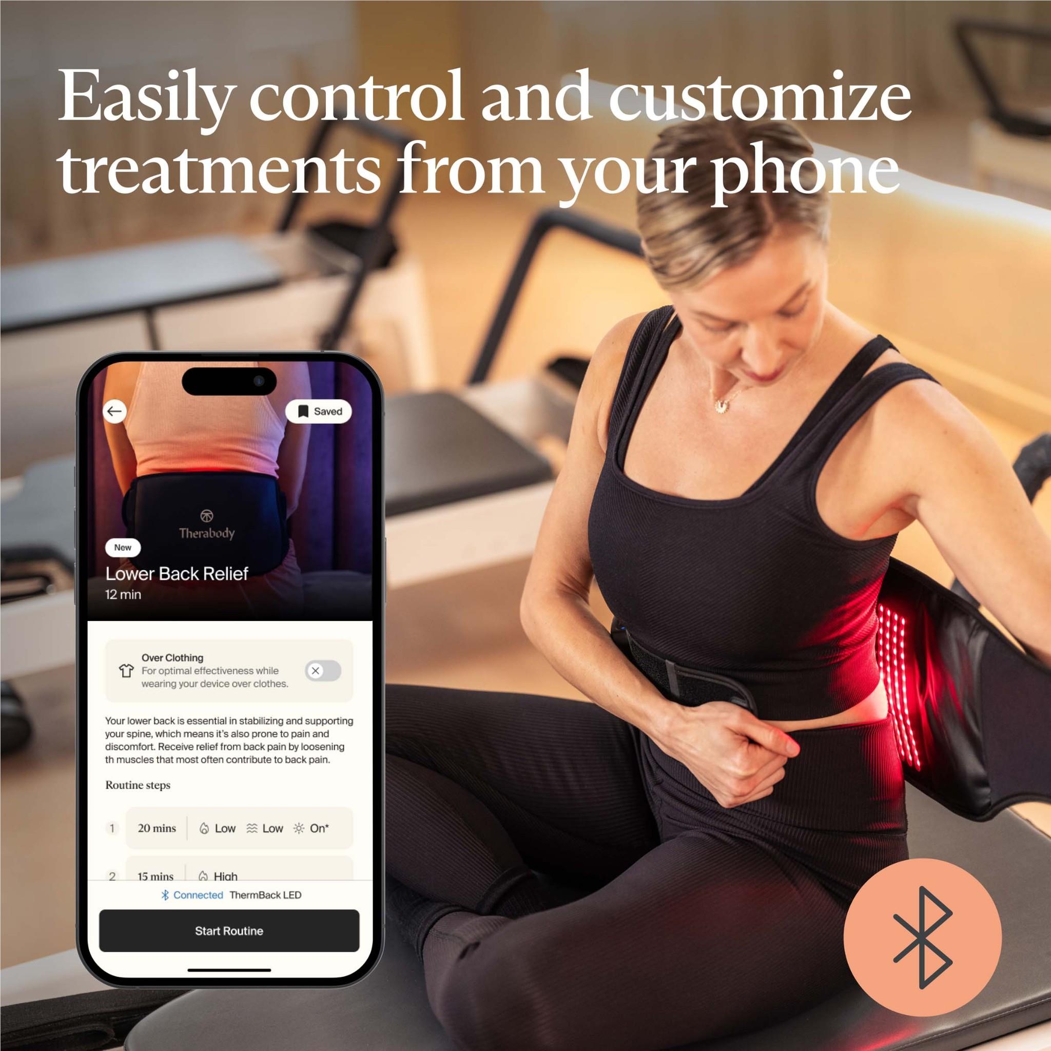 Therabody lower back wrap with red LED lights worn by a seated person