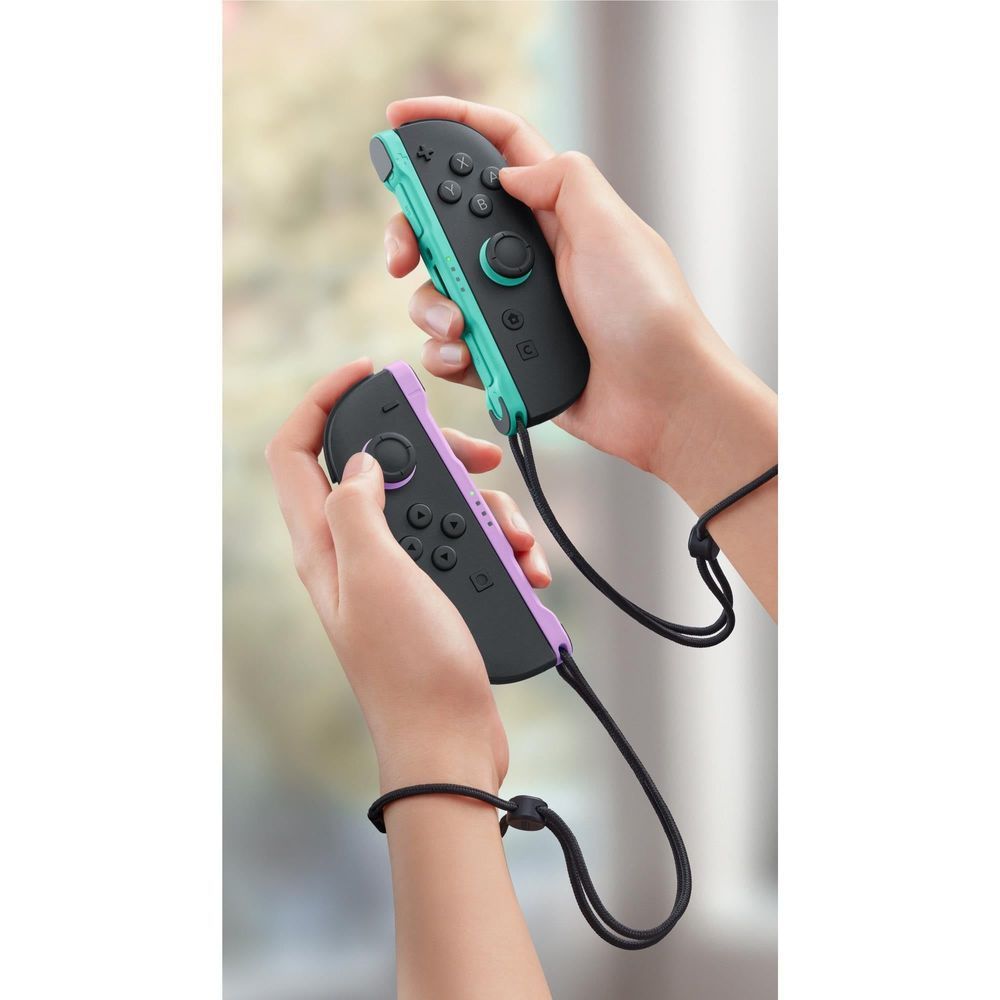 Hands holding teal and purple Joy-Con controllers with black buttons