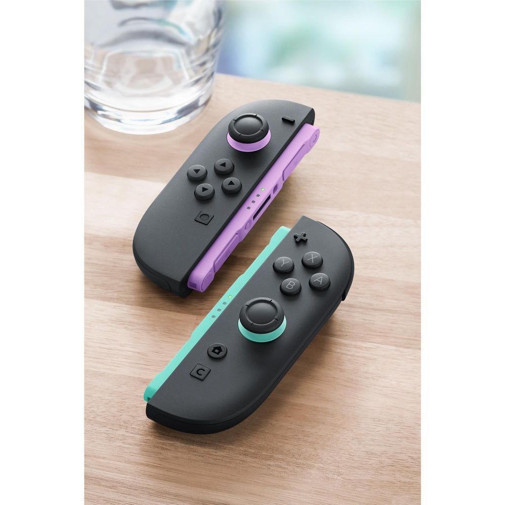 Joy-Con controllers resting on a table: purple and teal halves with black grips