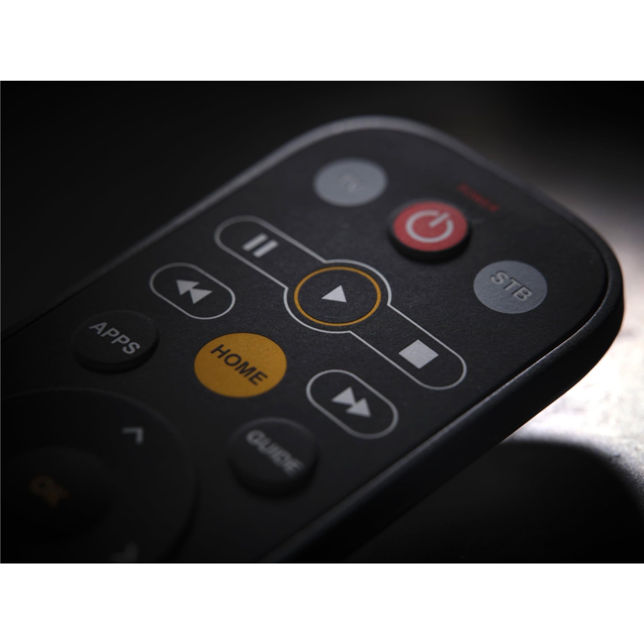 Close-up of universal TV remote top buttons: power, apps, home, and arrow controls.