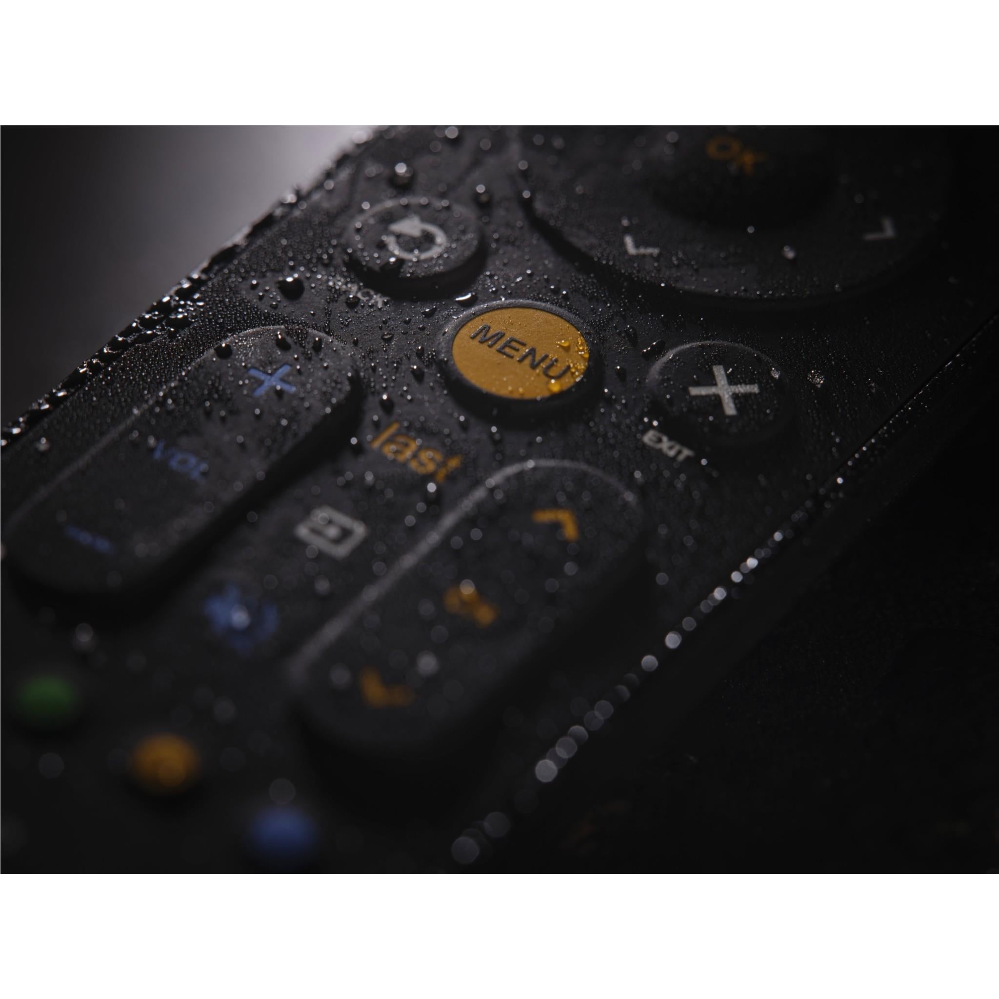 Close-up of universal TV remote buttons with visible water droplets on the surface.