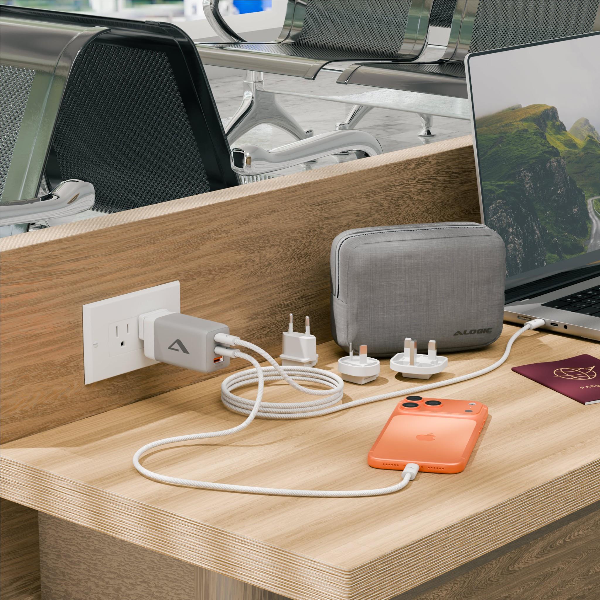 Travel charger with gray case, plug adapters, and charging cables by wall outlet