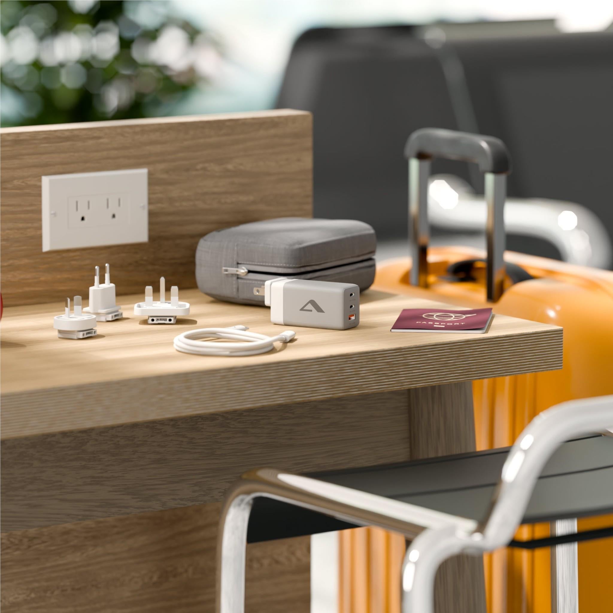 Compact travel charger kit with gray case, plug adapters, and charging cable
