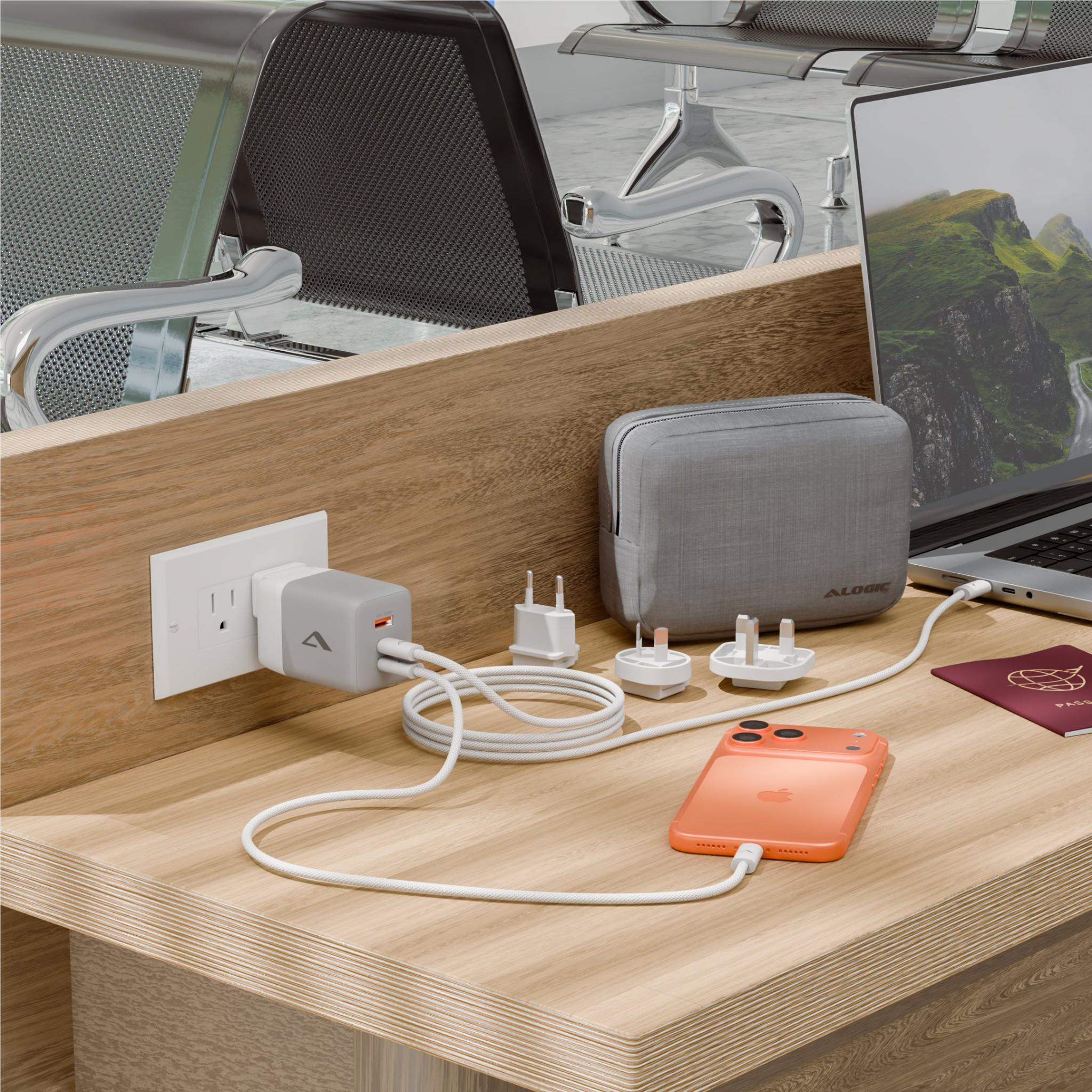 Travel charger kit with fabric case, plug adapters, and USB cables on desk