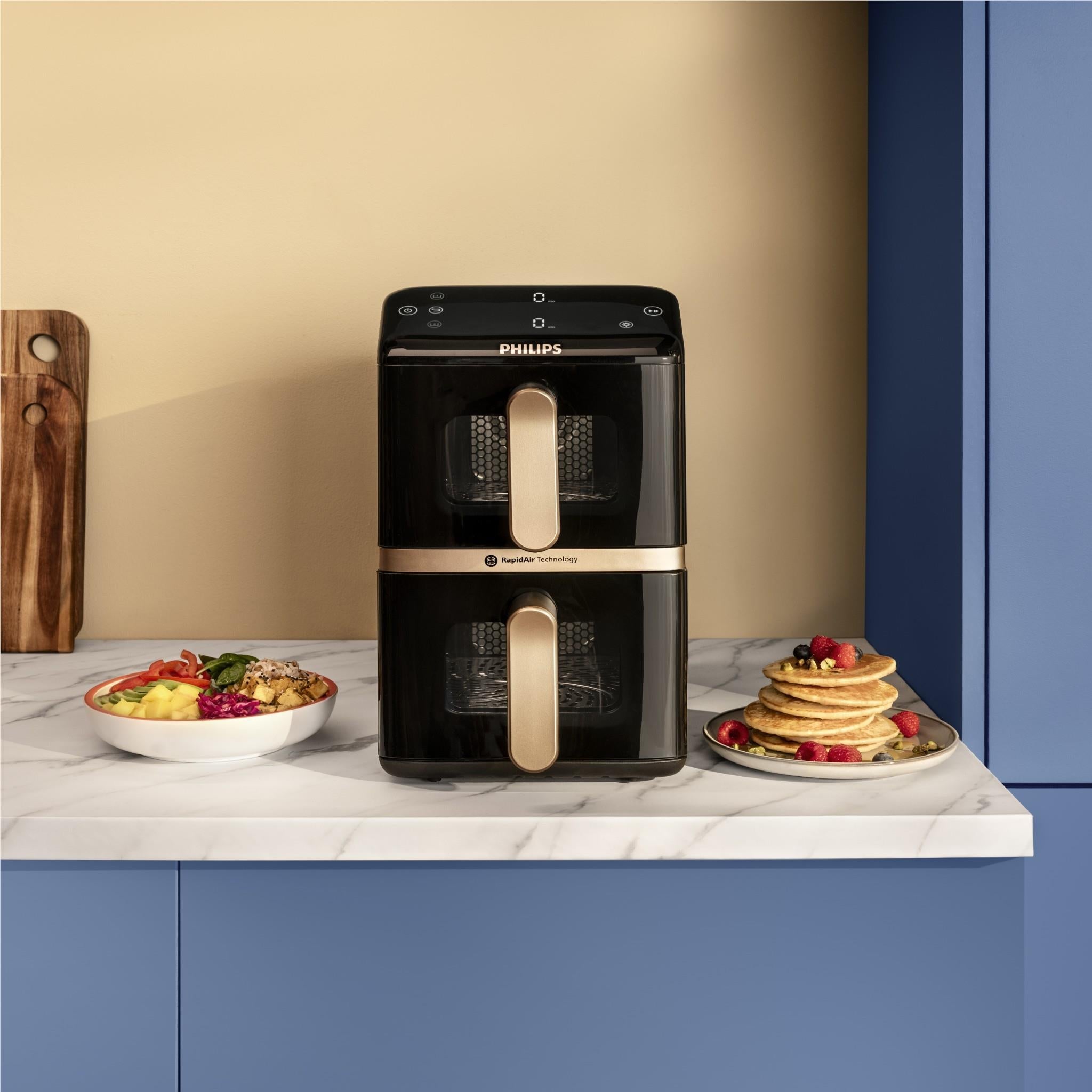 Stacked dual-basket air fryer on countertop with two open baskets and handles.