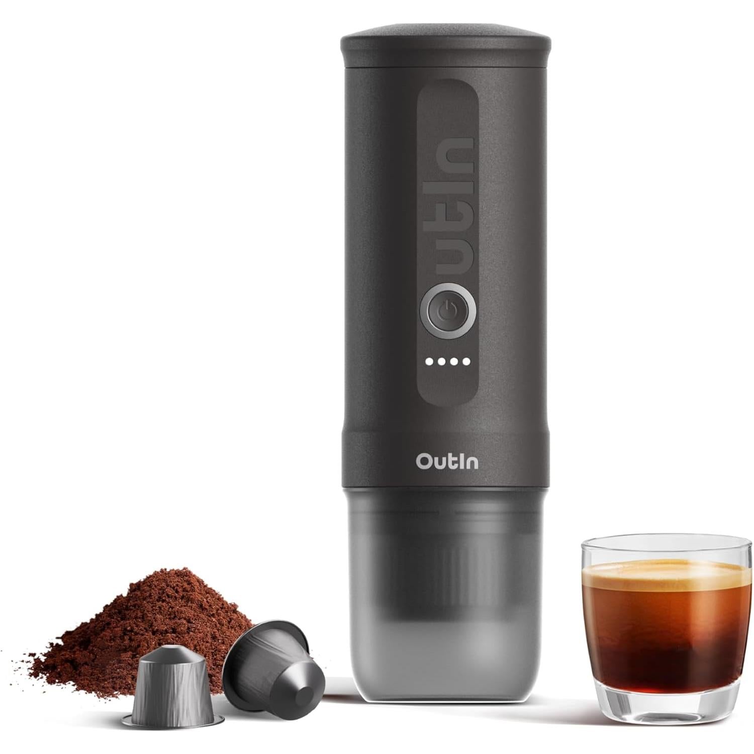 Portable electric espresso maker in dark gray with cup, coffee grounds, and glass