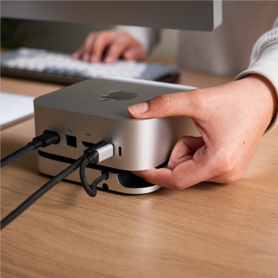 Silver Mac mini stand hub with black top, cable plugged into front ports