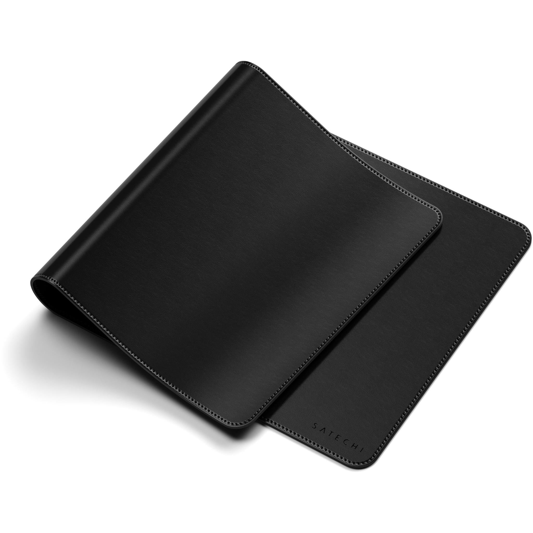 Black desk mat with stitched edges, shown folded back in layers