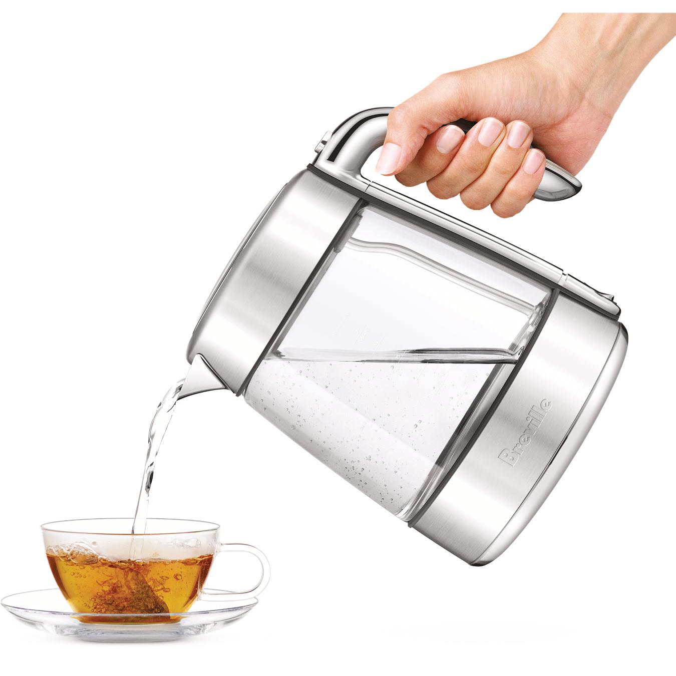 Stainless glass jug kettle pouring hot water with hand lifting the lid