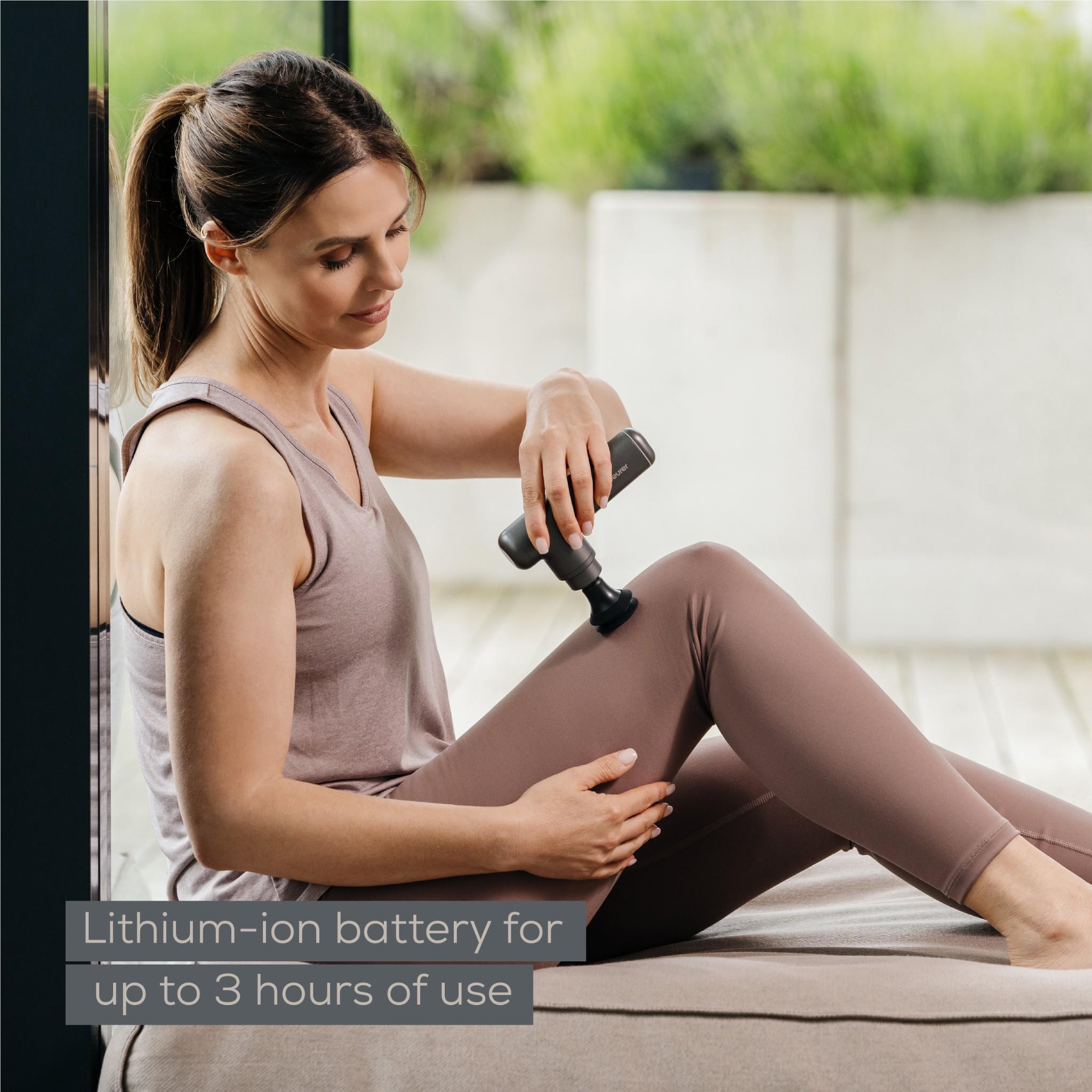 Grey massage gun using a small head on the leg