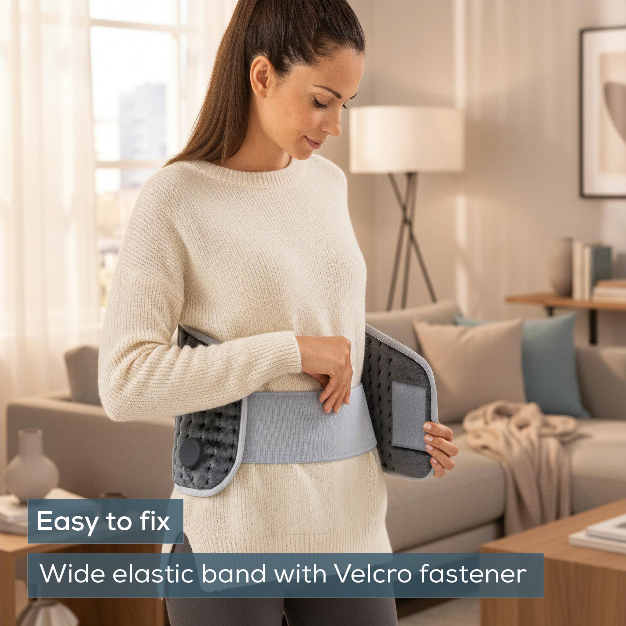Grey fleece heat pad worn on abdomen with wide elastic Velcro strap