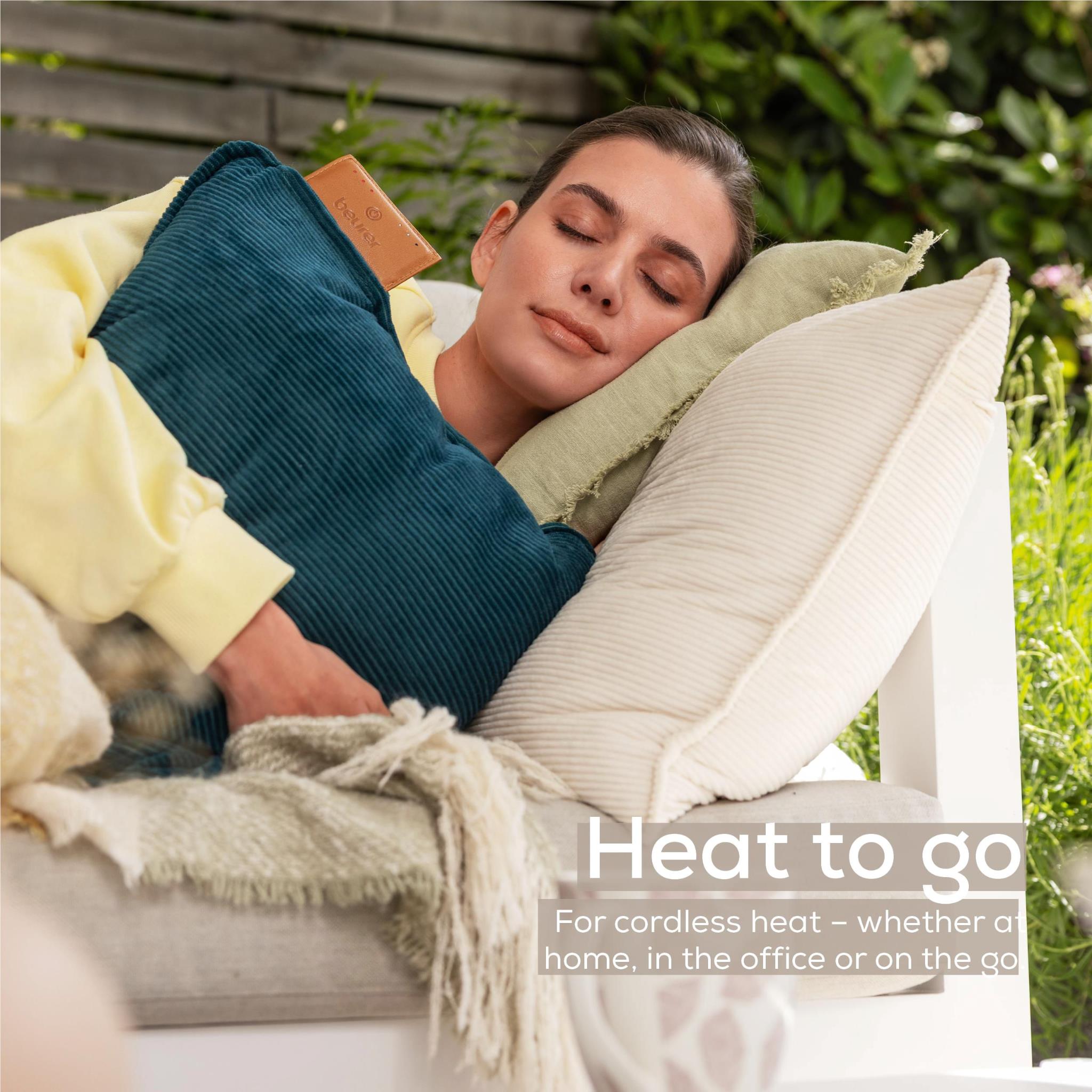 Cordless heated cushion with light cream ribbed cover resting on a couch.