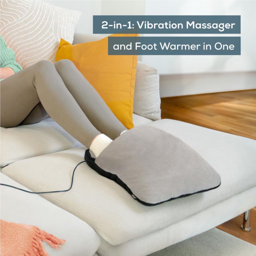 Grey heated foot massager cushion on couch with feet resting on it